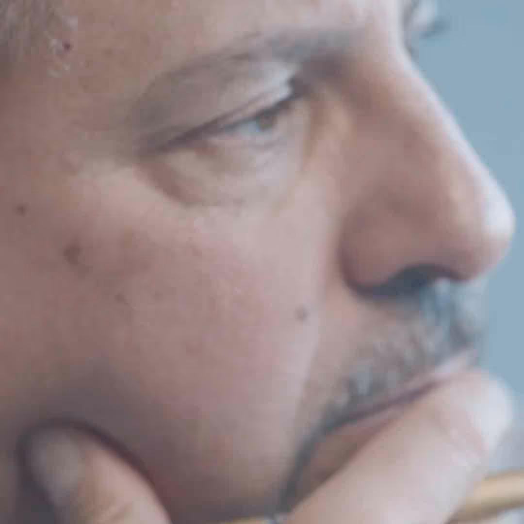Close-up side profile of a man resting his chin on his hand, appearing thoughtful.